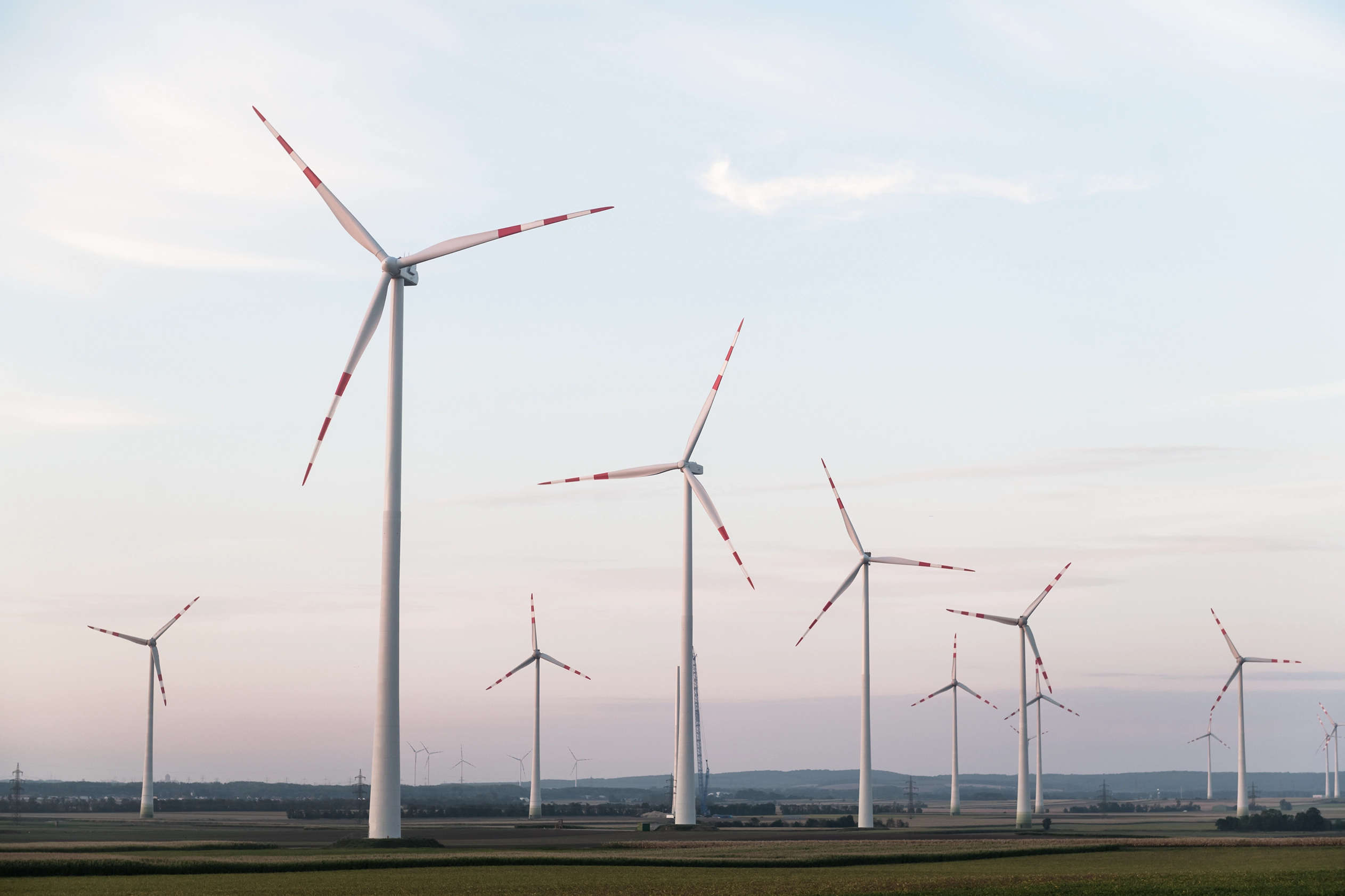 The picture shows a small wind farm at dusk.